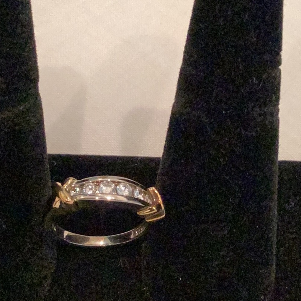 Cubic zirconia ring with gold tone X’s .